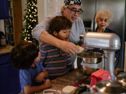 grandfather shows grandsons how to make greek cookies