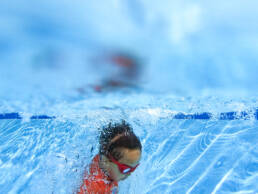 boy jumps into pool and takes his head under water